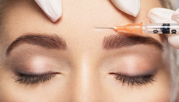 a person receiving a BOTOX injection between their eyebrows