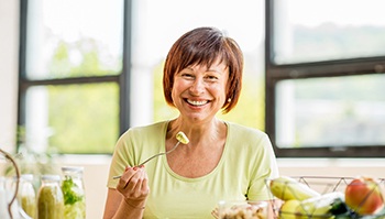 woman smiling and eating healthy foods