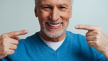 older man pointing to his smile