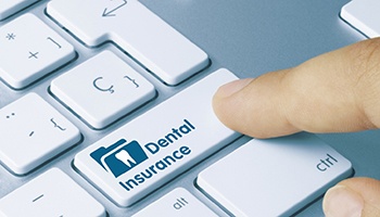 Finger pressing button on keyboard that says Dental Insurance