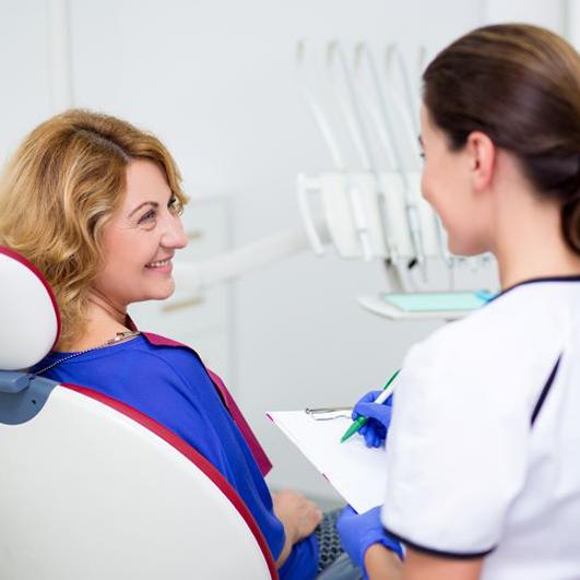 Dental team member conversing with patient 