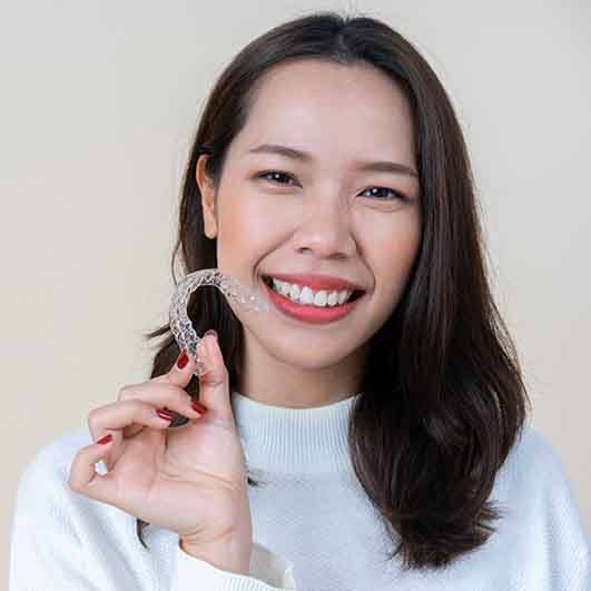 young woman holding nu smile aligners